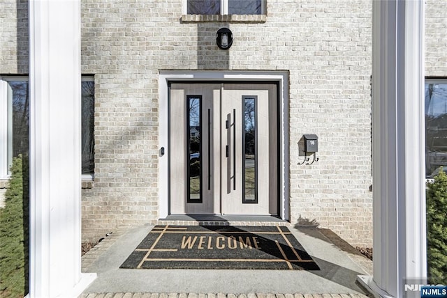 entrance to property featuring brick siding