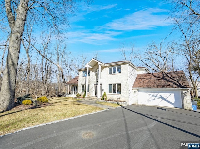 view of front of house with a garage, aphalt driveway, and a front yard