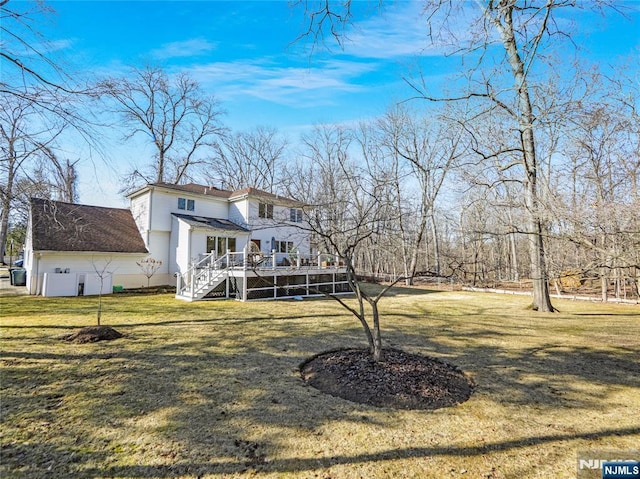 back of house with a deck, a lawn, and stairway