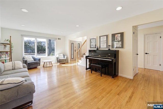 living area featuring stairs, light wood-type flooring, baseboards, and recessed lighting