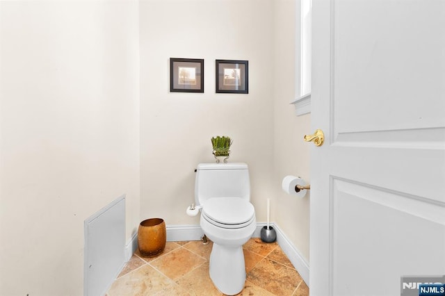 bathroom featuring toilet and baseboards