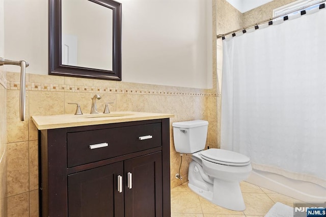 full bath with vanity, a wainscoted wall, tile patterned flooring, tile walls, and toilet