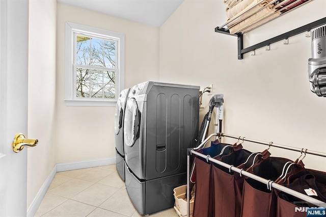 laundry room featuring laundry area, light tile patterned flooring, baseboards, and washing machine and clothes dryer