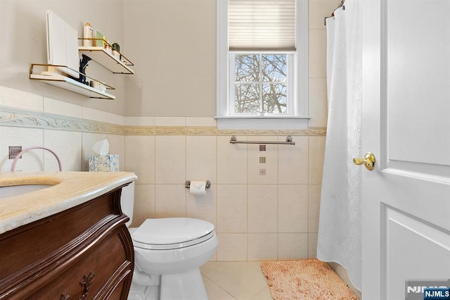 full bathroom featuring toilet, tile walls, vanity, and tile patterned flooring