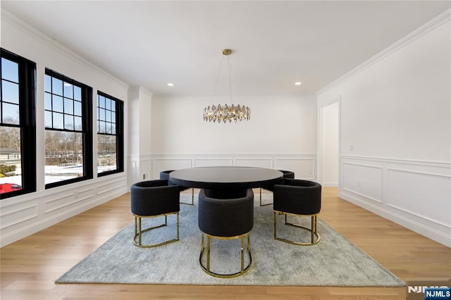 dining area with ornamental molding, a decorative wall, recessed lighting, and light wood-style floors