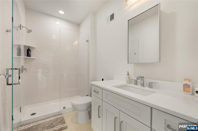 bathroom with toilet, a stall shower, vanity, and visible vents