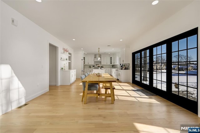 dining room featuring visible vents, baseboards, light wood-style flooring, and recessed lighting