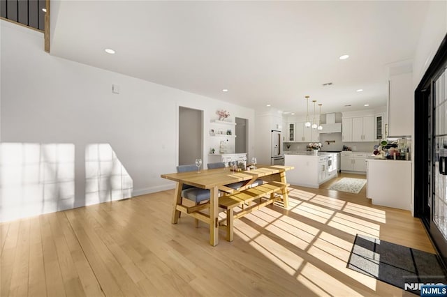 dining space featuring baseboards, light wood-type flooring, and recessed lighting