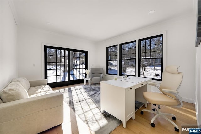 home office featuring ornamental molding, light wood finished floors, and baseboards