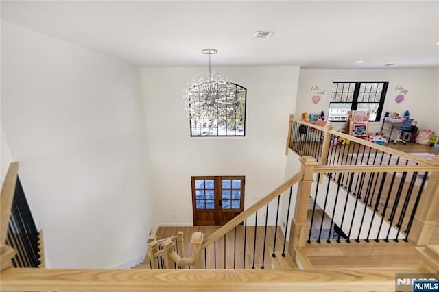 staircase with recessed lighting, visible vents, a notable chandelier, and french doors