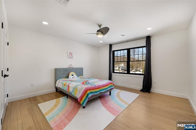 bedroom with light wood-style flooring, visible vents, and baseboards