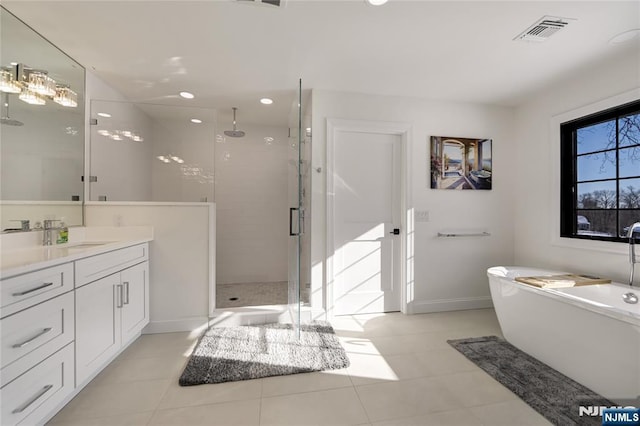 full bath featuring visible vents, a shower stall, vanity, a freestanding tub, and baseboards