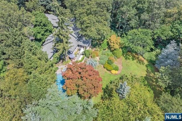 birds eye view of property featuring a forest view