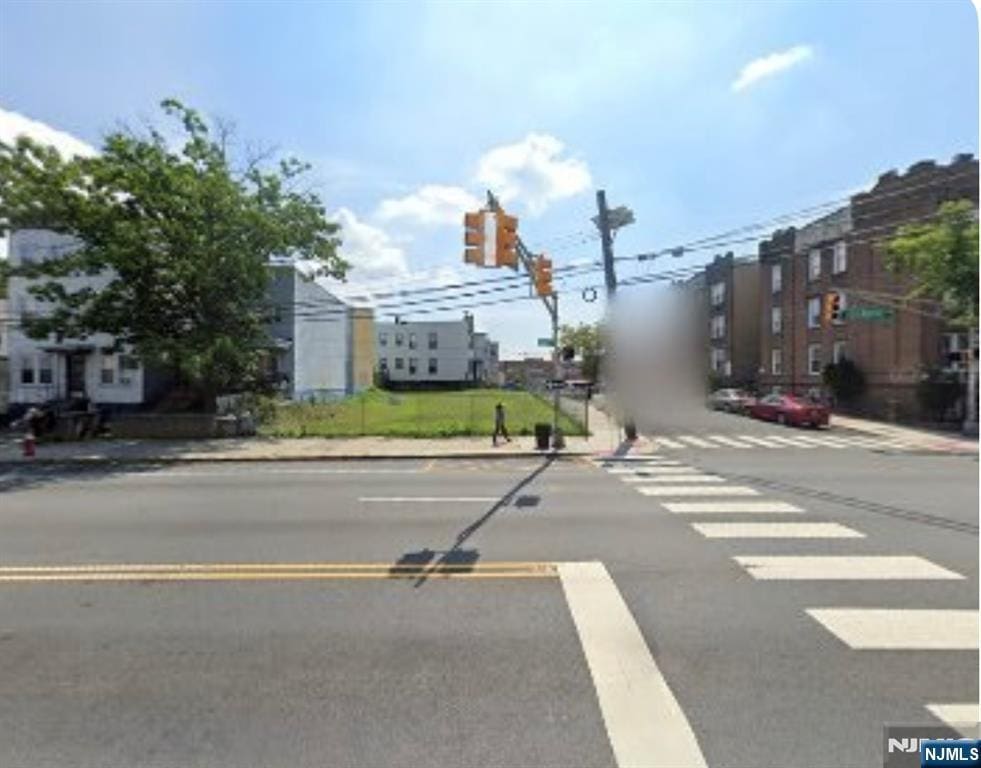 view of road with sidewalks, traffic lights, and curbs