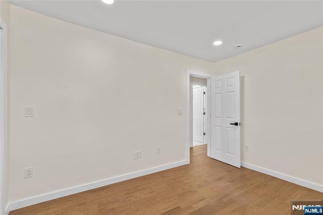 empty room featuring recessed lighting, light wood-style flooring, and baseboards