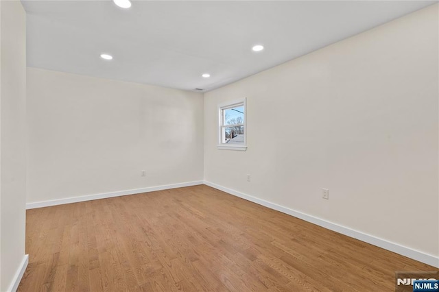 spare room with light wood-type flooring, baseboards, and recessed lighting