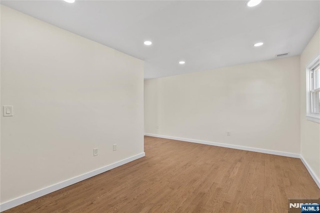 unfurnished room featuring light wood-type flooring, baseboards, and recessed lighting