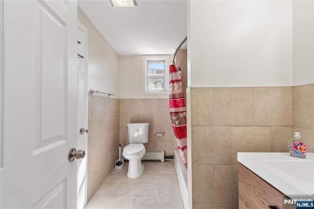 bathroom featuring toilet, tile patterned flooring, vanity, a baseboard heating unit, and tile walls