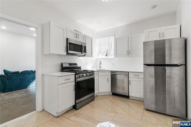 kitchen with light countertops, appliances with stainless steel finishes, and white cabinetry