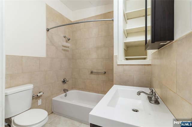 full bath with shower / bath combination, toilet, tile patterned floors, vanity, and tile walls