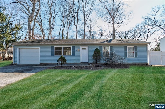 ranch-style home with a garage, driveway, fence, and a front lawn