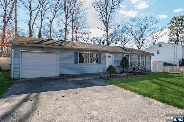 ranch-style home featuring driveway, a front lawn, an attached garage, and fence