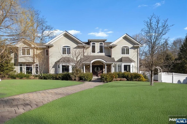 view of front of house with a front yard and fence