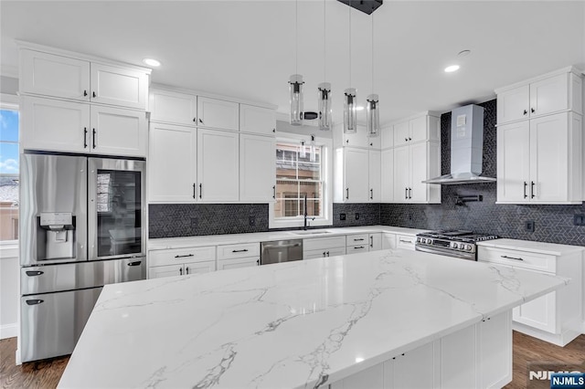 kitchen with white cabinets, wall chimney range hood, plenty of natural light, and stainless steel appliances