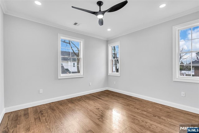 spare room with visible vents, a wealth of natural light, and crown molding