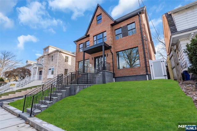 view of front of home featuring a front lawn and brick siding