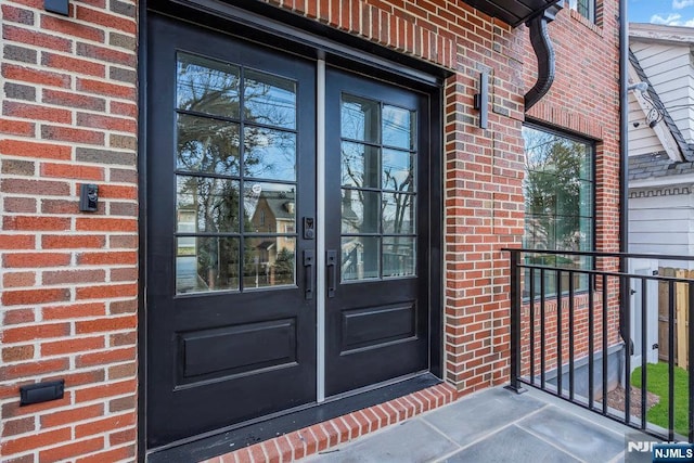 entrance to property featuring french doors and brick siding