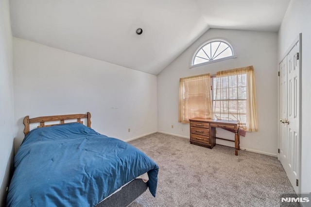 carpeted bedroom with lofted ceiling and baseboards