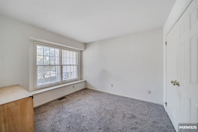 interior space with carpet flooring, visible vents, and baseboards