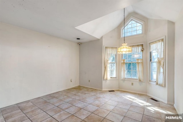 unfurnished room with vaulted ceiling, light tile patterned floors, visible vents, and baseboards