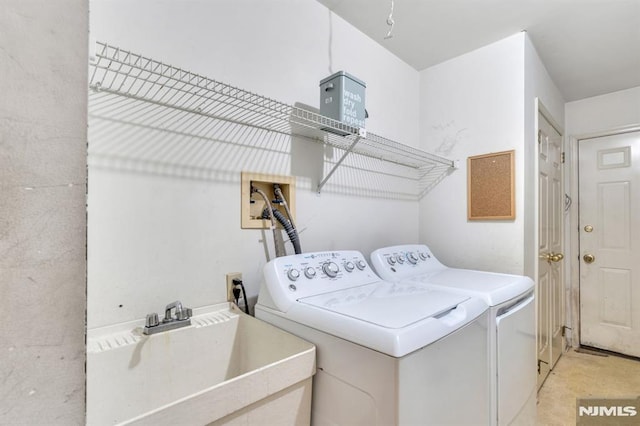 laundry room featuring laundry area, separate washer and dryer, and a sink