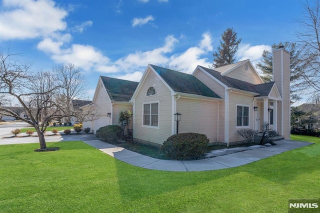 view of side of property with a chimney, an attached garage, and a lawn