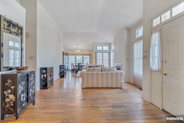 living room featuring a high ceiling, an inviting chandelier, and wood finished floors