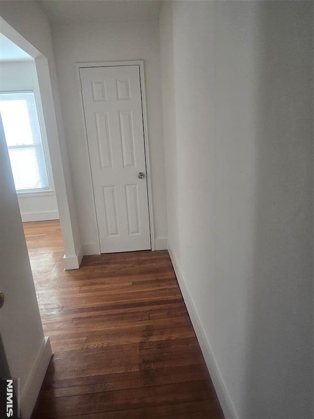 hallway with wood finished floors and baseboards