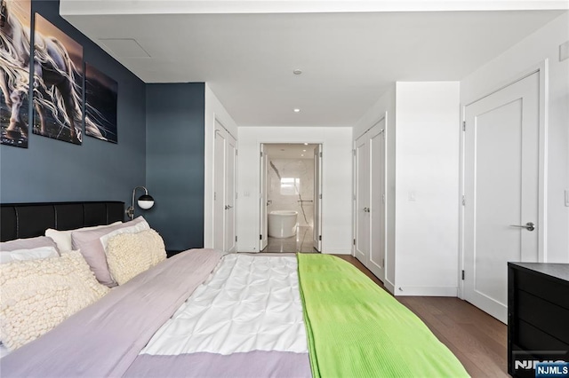 bedroom featuring baseboards, wood finished floors, and ensuite bathroom