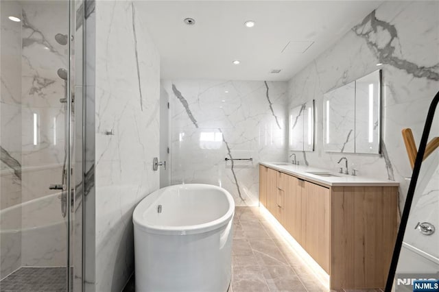 full bath featuring stone wall, a marble finish shower, tile walls, and a sink