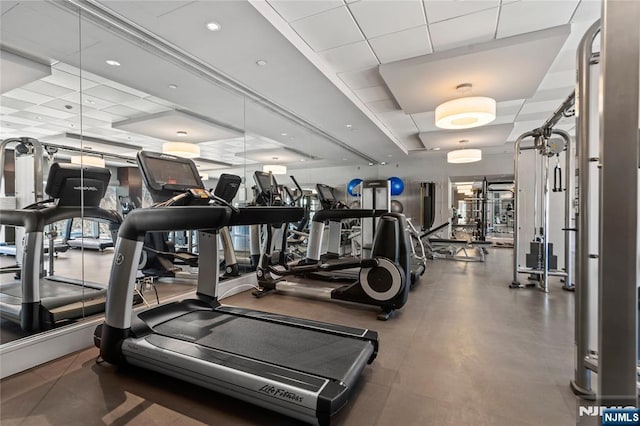 workout area featuring a tray ceiling and a drop ceiling