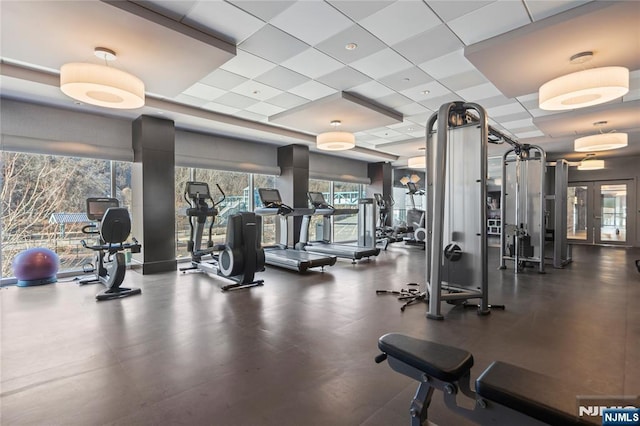 workout area with a paneled ceiling and french doors