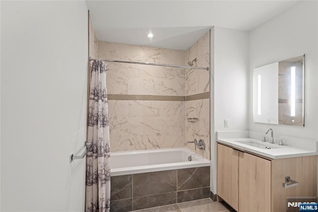 bathroom featuring tiled shower / bath combo and vanity