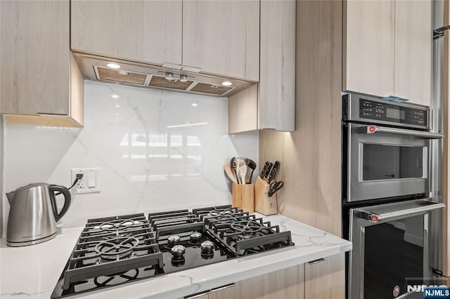 kitchen with range hood, modern cabinets, and stainless steel double oven