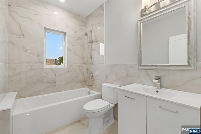 bathroom with toilet, shower / tub combination, marble finish floor, vanity, and tile walls