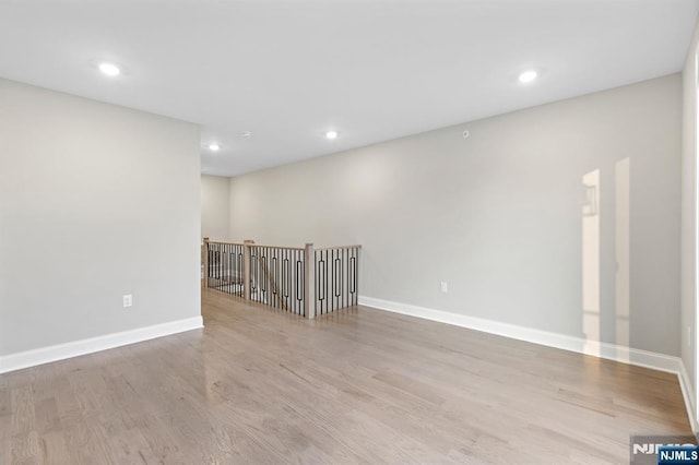 unfurnished room with recessed lighting, baseboards, and wood finished floors