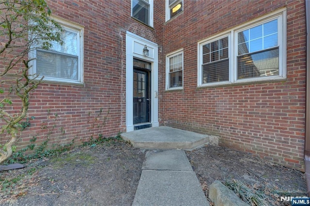 entrance to property featuring brick siding