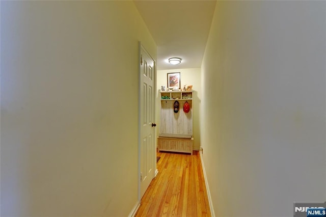 hallway featuring light wood-style floors and baseboards