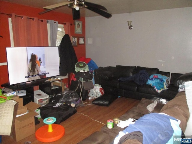 living area with a ceiling fan and wood finished floors