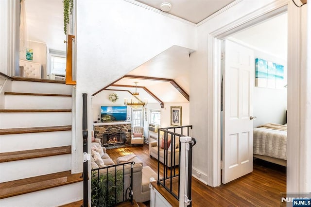 stairs featuring hardwood / wood-style floors, a fireplace, and crown molding